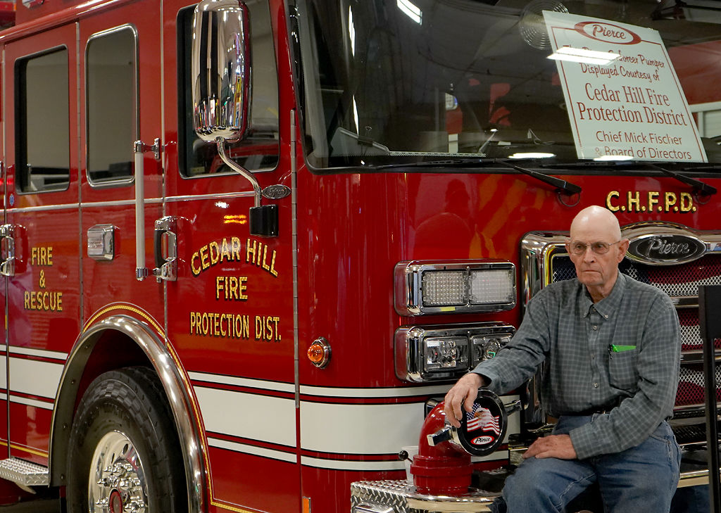 Richard Nolker sits beside a firetruck